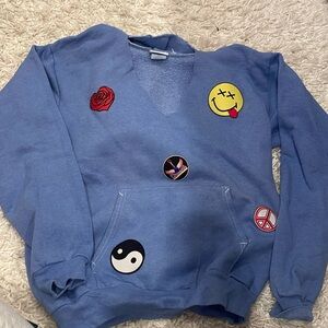 Blue hoodie with cut neck 
Cool/trendy designs 
Small 
Slightly worn